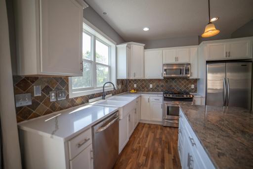 Kitchen with stainless appliances, quartz and granite counters