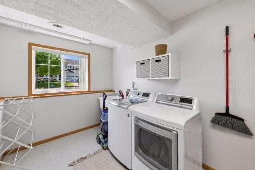 Bright laundry area with additional space for storage, a freezer, or a second refrigerator.