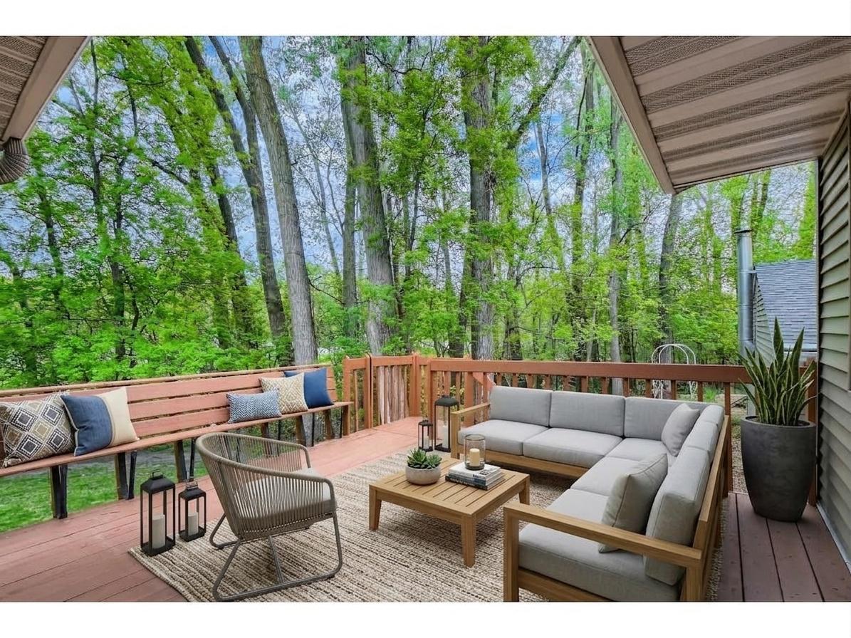Expansive back deck overlooking a lush, private wooded yard. Features built-in bench seating and ample room for an outdoor living setup. *Virtually staged to show design options.