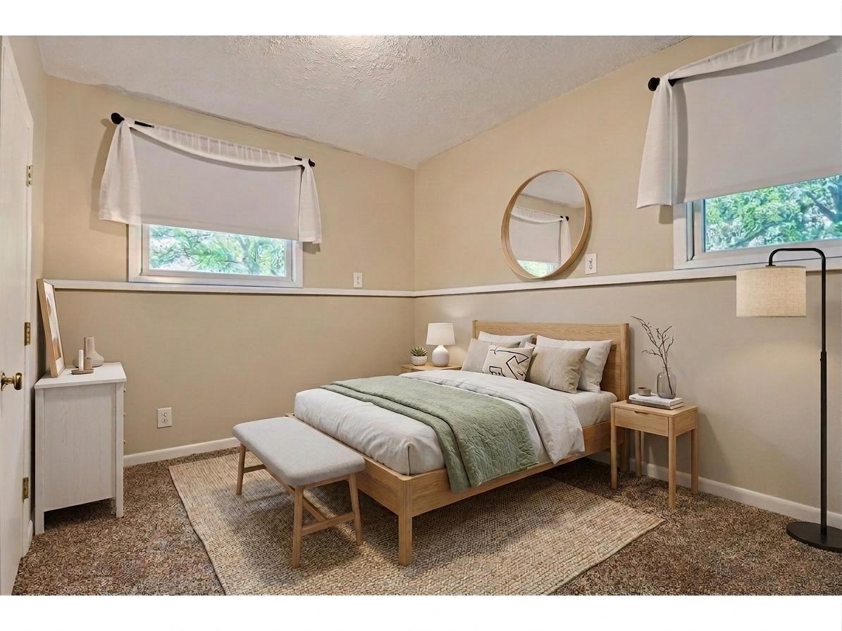 The third bedroom, located on the lower level, features warm neutral tones, and two bright lookout windows allowing for plenty of natural daylight. *Virtually staged to show design options
