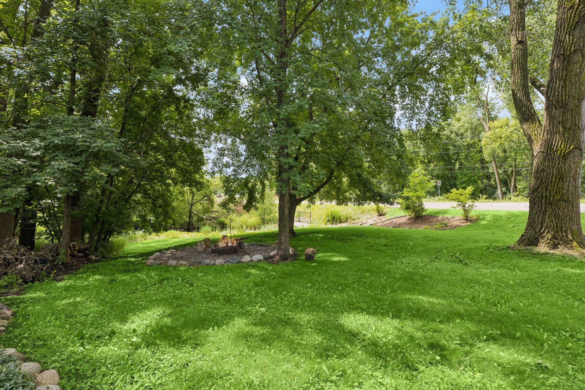 Another view of the expansive yard showcasing the mature, private trees that create a beautiful, park-like setting right at home!