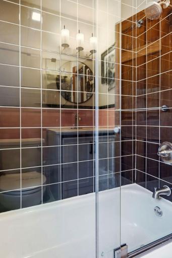 Main-level bathroom with updated tiled tub and shower.