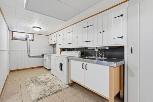 Lower-level laundry and utility area with abundant storage.