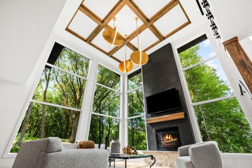 Striking coffered ceiling with exposed wood beam detailing adds architectural character and warmth to the soaring great room.