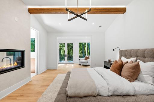 Vaulted beam ceilings, double sided fireplace, and sitting room with access to the private balcony.