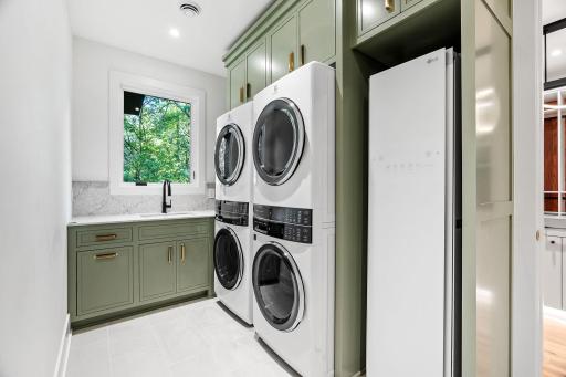 Upper level double laundry room with sink and steam closet for steaming clothes