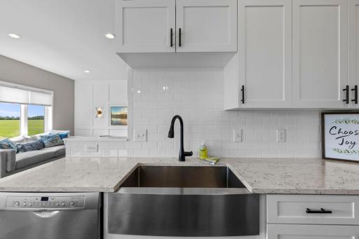 Stunning Stainless Steel Farmhouse sink beautifully accepted by Subway tiled basksplash.