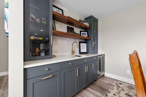 WOW! Gorgeous wetbar featuring stylish, modern color, open shelving and tiled backsplash.