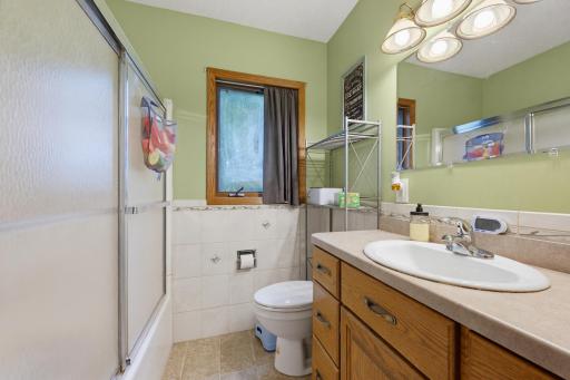 The full bathroom features an oak vanity.