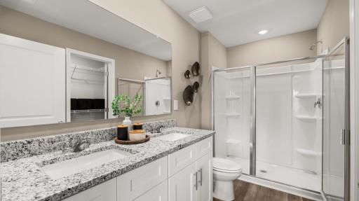 Primary bath. Actual home will include quite quartz countertops. All photos used are of a previous model home.