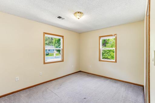 Inviting bedroom with new window blinds, generous natural light, and a spacious layout.