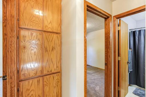 Hallway offering generous built-in cabinetry for extra storage and a functional layout.