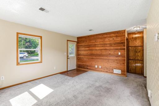 Inviting living area with picture window, fresh paint, and charming wood accent wall.