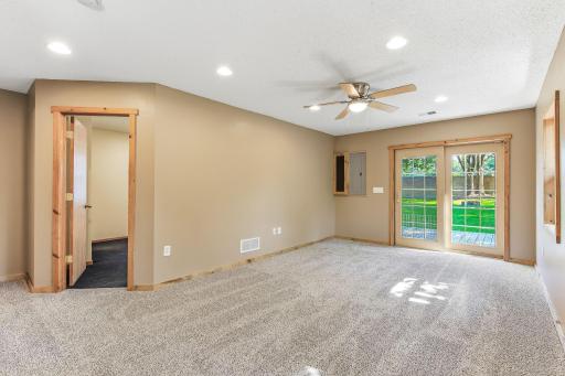 Alternative view of family room adjacent to the primary bedroom featuring new carpet, ceiling fan, and walkout to the backyard.