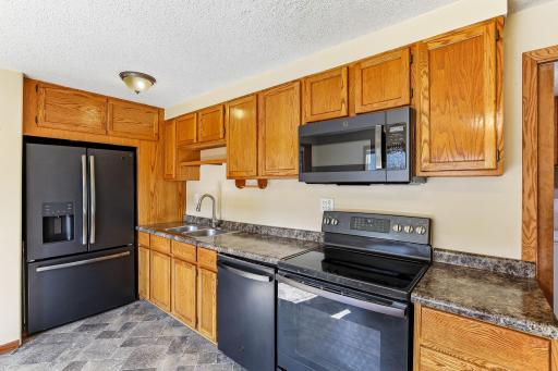 Kitchen offering ample cabinetry, an expansive workspace, and updated black appliances installed about 2 years ago.