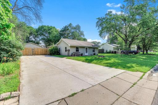 Wide-angle view of the front exterior showcasing the home's large lot, long driveway, and attractive curb appeal.