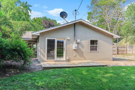 Back of the home showcasing a private deck, durable low-maintenance exterior, and backyard access.