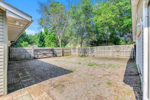 Convenient fenced side yard with wide gate access, offering additional outdoor storage and utility space.