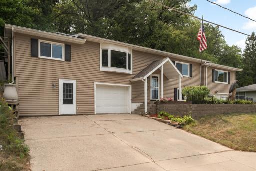 Stately entrance to this home on the hill. Add a full size garage door for a third garage stall or use the service door area for storage or workshop.