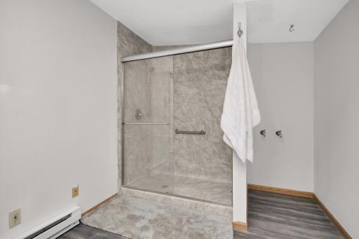 Updated walk in shower is large and modern.