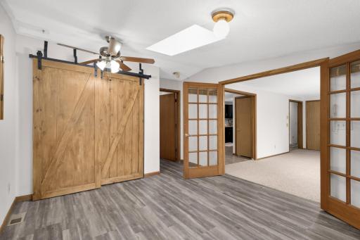 Closet with sliding barn door access on the left, primary bath entrance to the right.