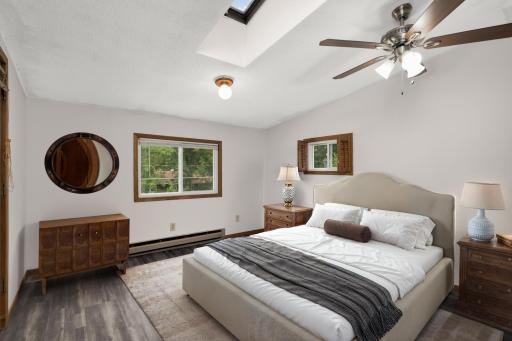 Large primary with vaulted ceiling, skylight and fan. Virtually staged to show potential