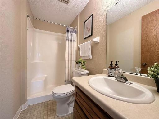 Lower level 3/4 bathroom featuring a standing shower and toilet.