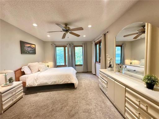 Spacious primary bedroom with multiple large windows that fill the room with natural light, along with a generous walk-in closet.