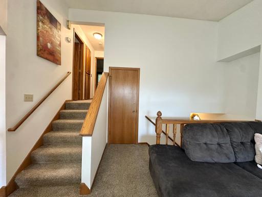 A comfortable staircase leads to the upper level, featuring two bedrooms and a full bathroom.
