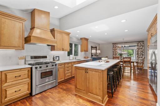 Fully remodeled Gourmet Kitchen w/ custom cabinetry, oversized island, quartz counters, SS apps + beverage fridge