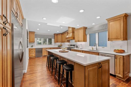 Fully remodeled Gourmet Kitchen w/ custom cabinetry, oversized island, quartz counters, SS apps + beverage fridge