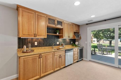 Walk-out Lower Level w/ Family Room, entertainment bar, gaming space + wet bar