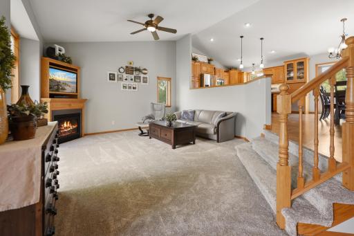 Main floor living room features new carpet, vaulted ceilings, and a gas fireplace.