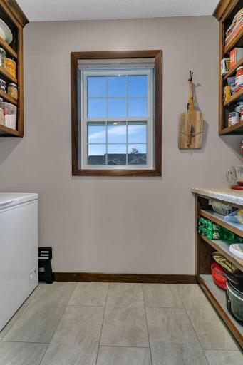 Extra storage and prep space in the walk in pantry with a window.