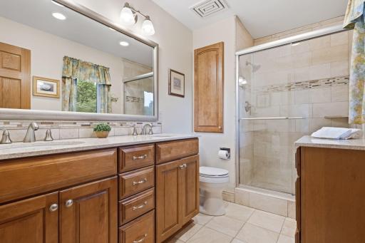 Private primary bathroom with dual sink vanity and walk-in shower