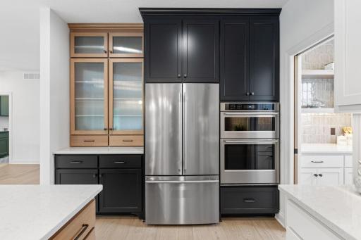 The kitchen also features stainless steel appliances, including a built-in wall oven and a gas range, offering both style and exceptional cooking versatility.