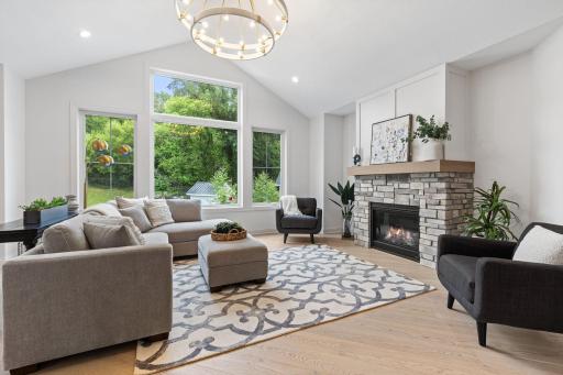 The great room is a true showpiece, highlighted by soaring 13’ vaulted ceilings, expansive Andersen windows that flood the space with natural light, and rich white oak engineered hardwood floors.