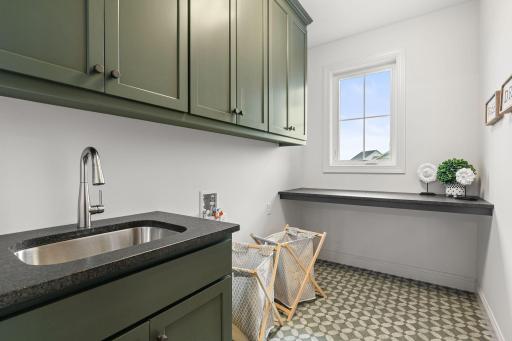 The convenient main-floor laundry room offers functional workspace, ample storage, and easy accessibility to simplify daily chores.