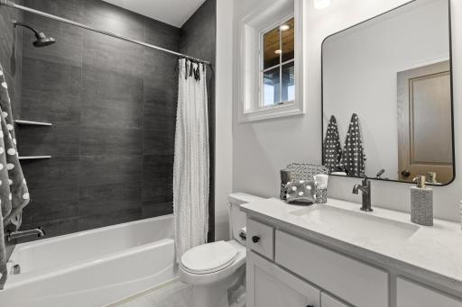 The main floor full bath features stylish finishes, a spacious vanity, and a tub/shower combination for everyday comfort and convenience.