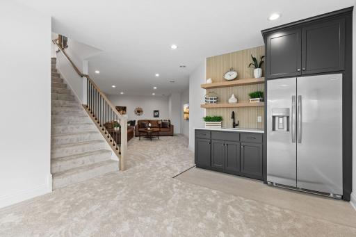 A stylish wet bar with a full-size refrigerator elevates entertaining.