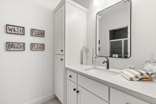 The nearby 3/4 bathroom features modern finishes and a walk-in shower, providing convenience and privacy for guests.