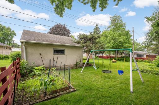 Play set and vegetable garden by the 2 car garage.