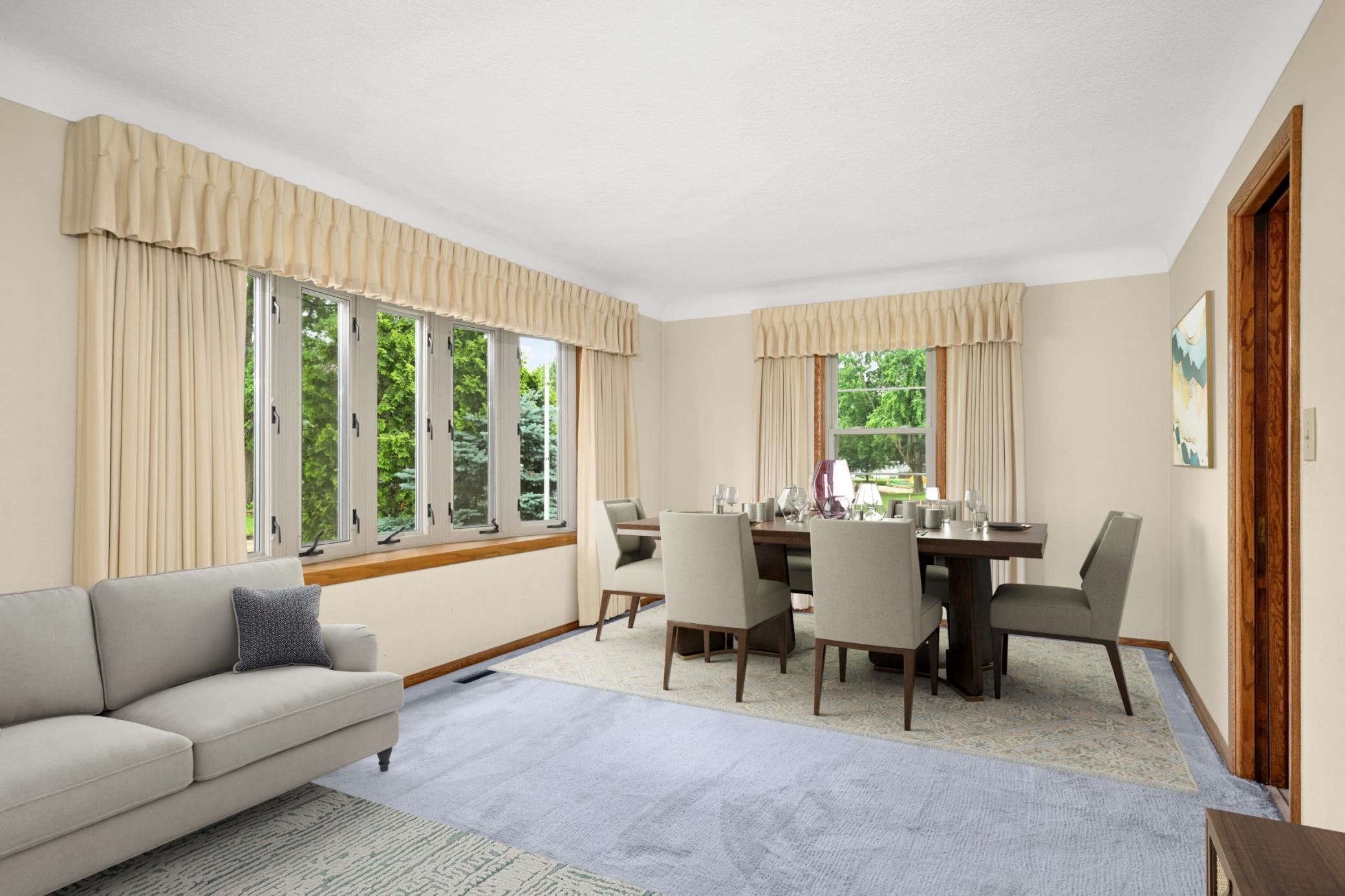 Living / dining room with bay window. Original hardwood floors under the carpet.