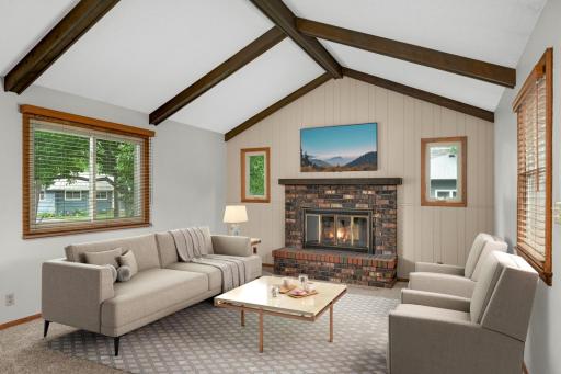 Coveted main floor Family Room with vaulted ceiling, wood burning fireplace, and new carpeting.