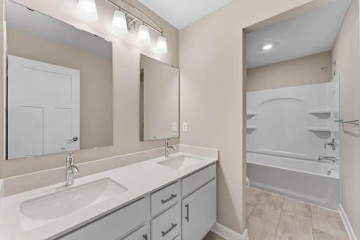 This full bathroom is conveniently located on the second floor and showcases dual sinks and a shower-tub combination.