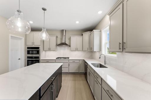 This stylish kitchen showcases a large center island, Shaker-style cabinetry, and brand-new stainless-steel appliances.