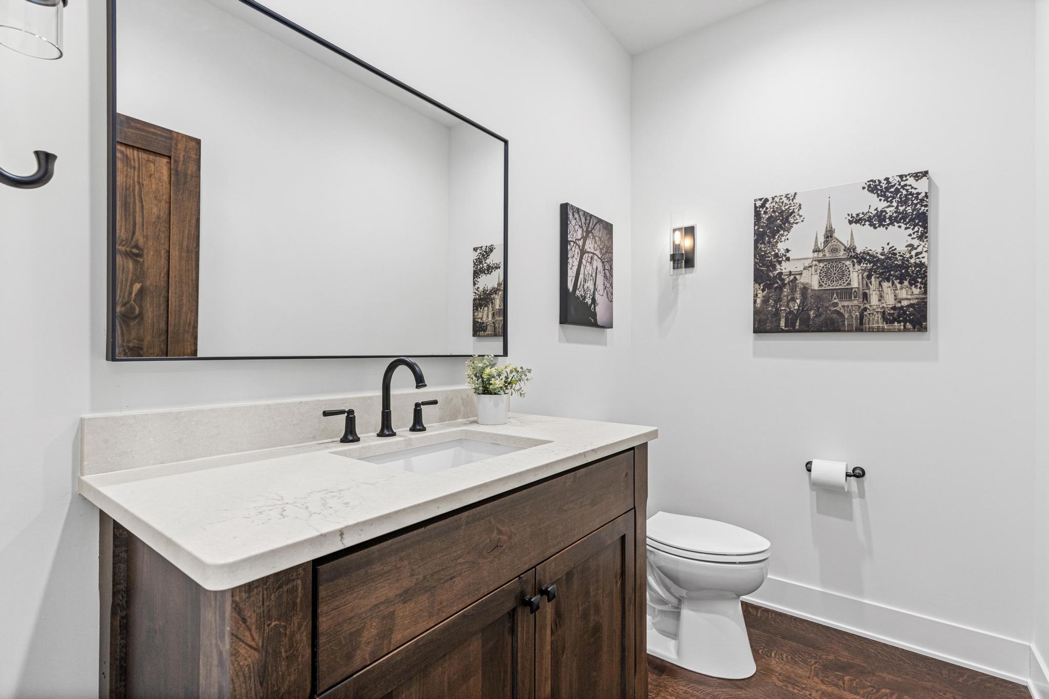 Main floor half bathroom- private and oversized for guests, located near the mudroom and second bedroom.