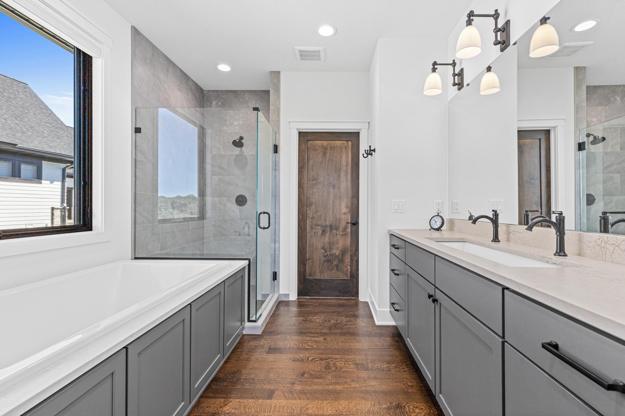 Every detail has been carefully selected to create a timeless and elegant retreat. Large walk-in shower and spa-like soaking tub. Beyond is the walk-in closet.