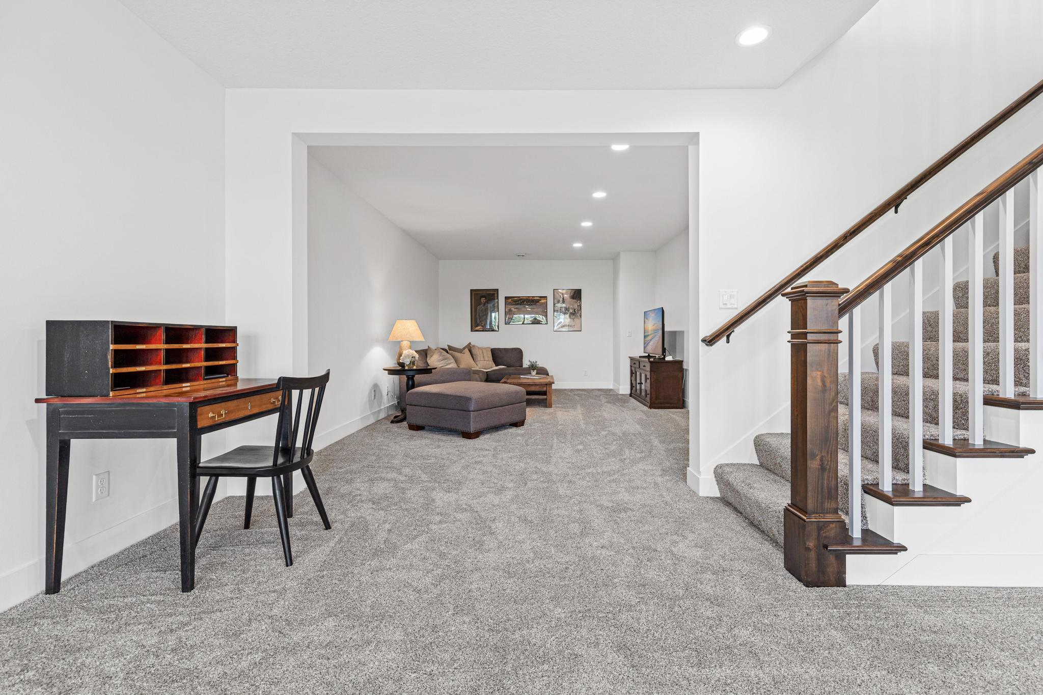 Upon landing in the lower level, a large room greets you on the right side. This is currently being used as a movie area, but also could be an office, exercise room or craft area.
