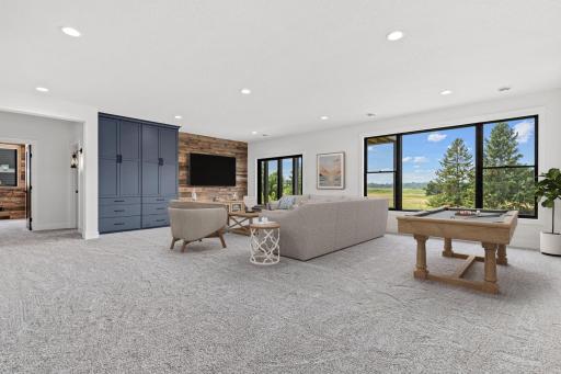 Downstairs, an entertainer's delight. Walk out lower level with large windows connecting interior spaces to the outdoors. The perfect place to watch the big game or your favorite movie. Virtually staged.